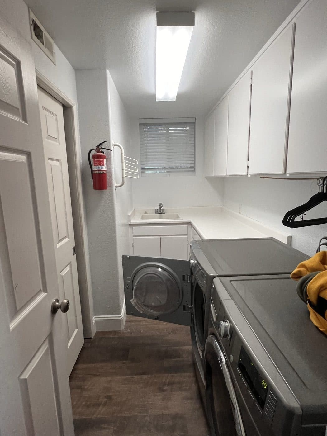 Finished laundry room remodel with new cabinetry, sink, and flooring
